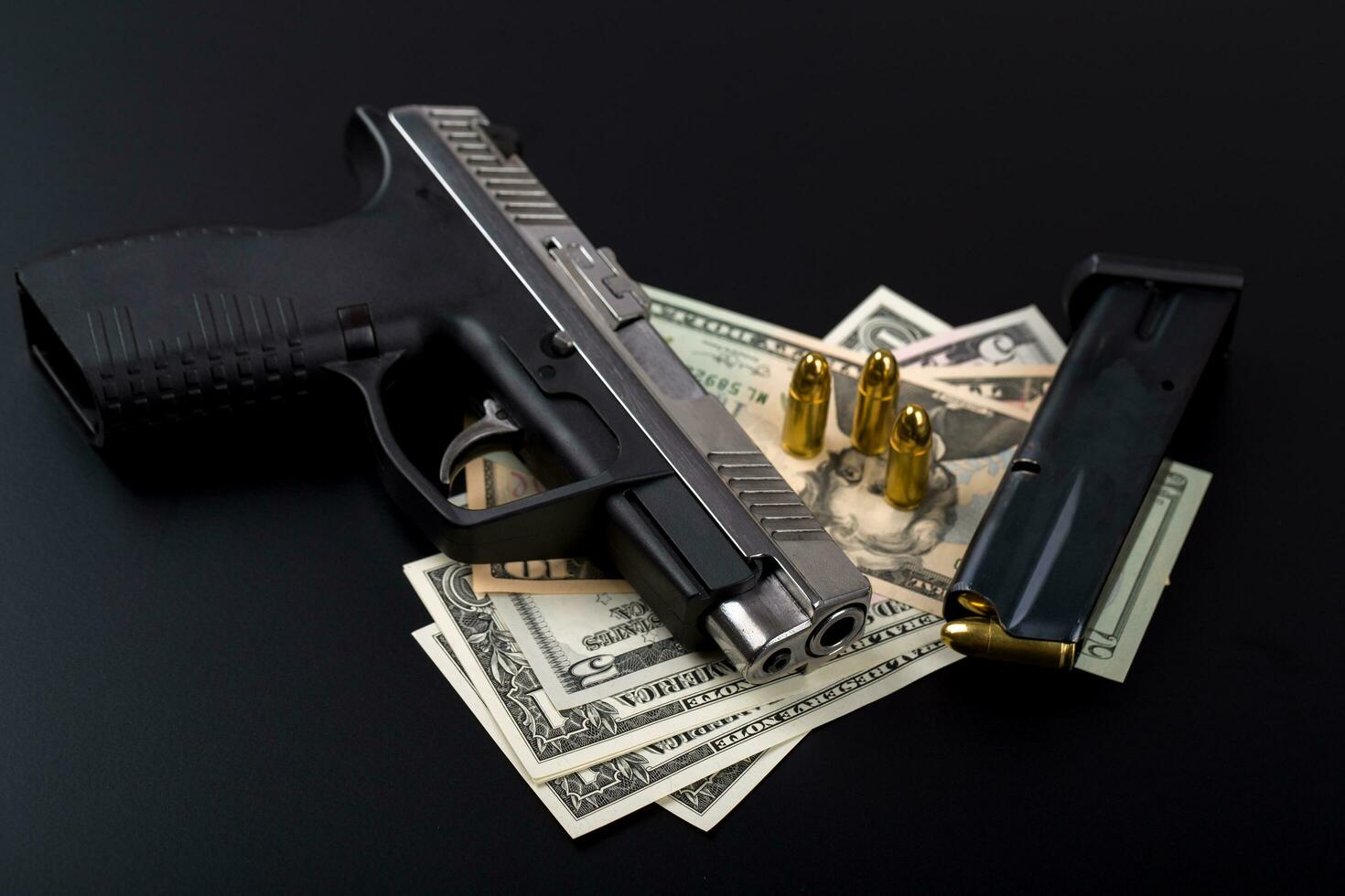 pistola con bala en billetes de dólar estadounidense foto