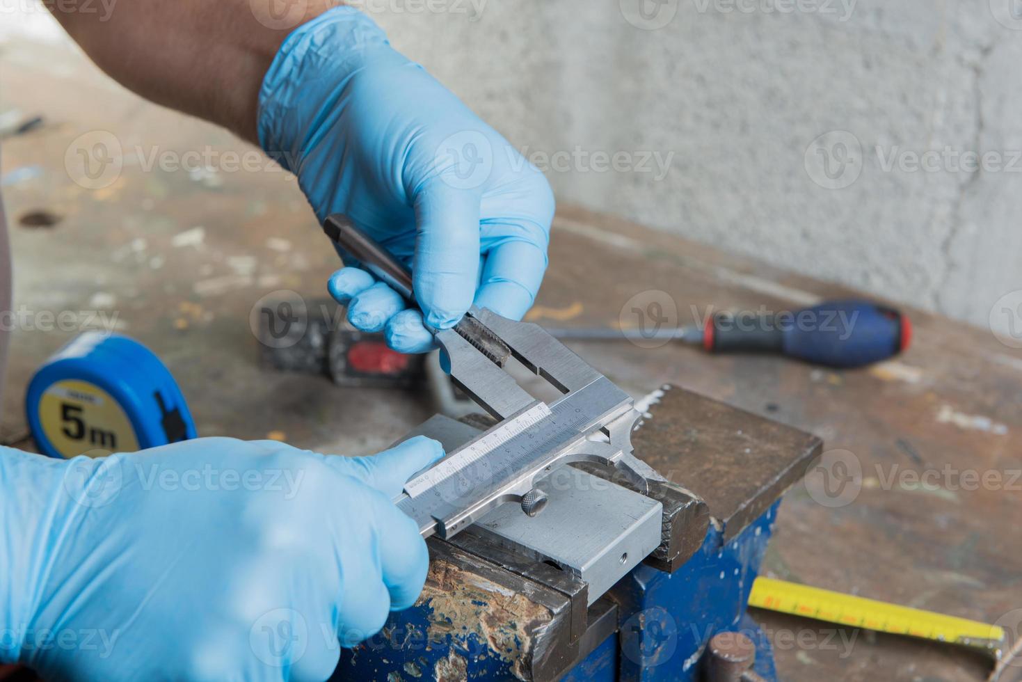 mechanic with blue gloves and a vernier caliper photo