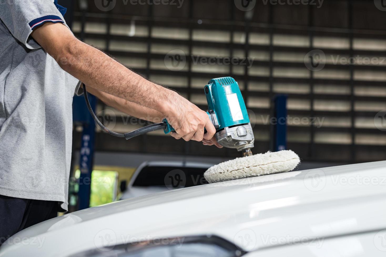 Car polishing series : Worker waxing white car photo