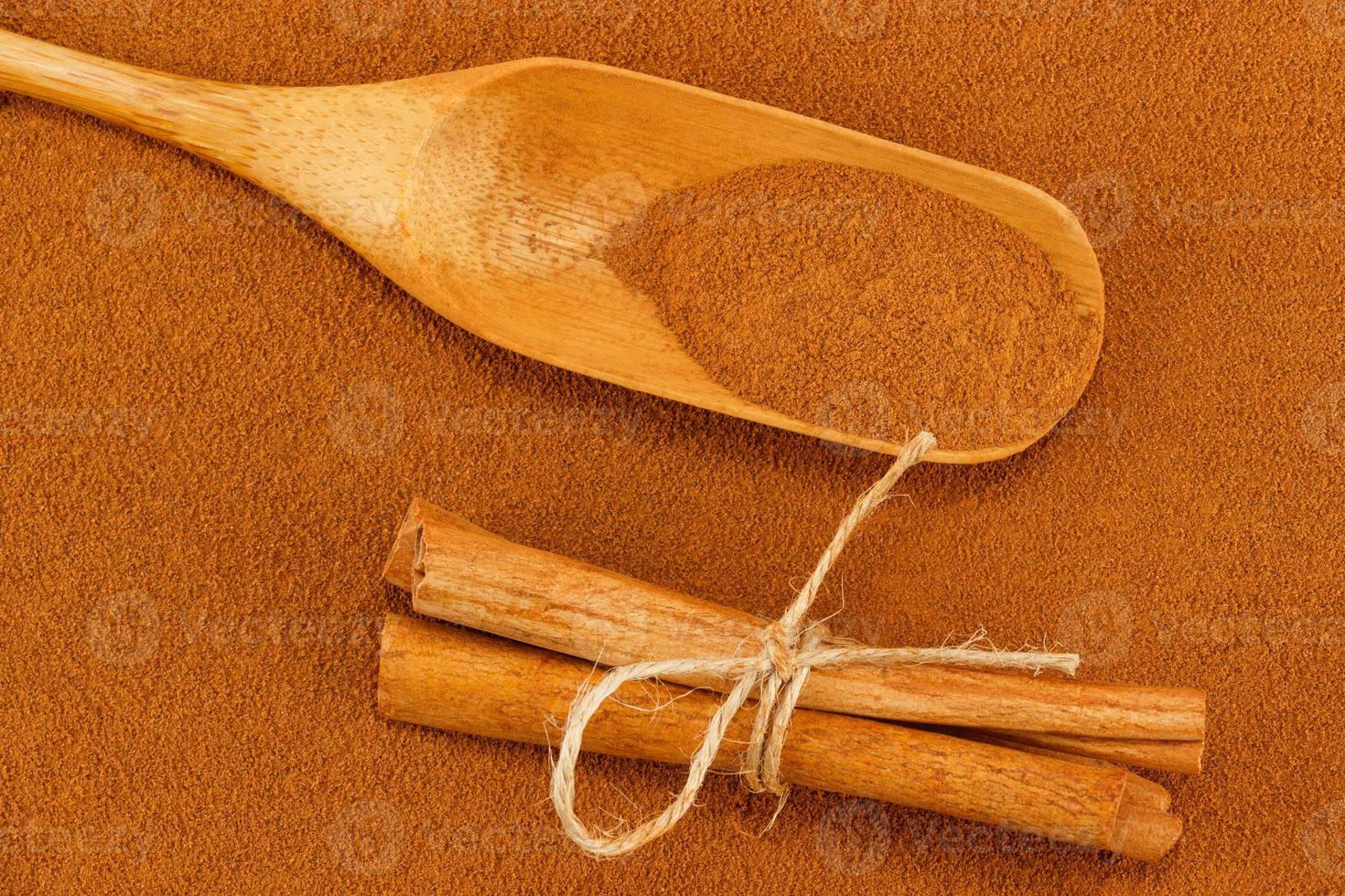 Cinnamon powder, sticks and scoop photo