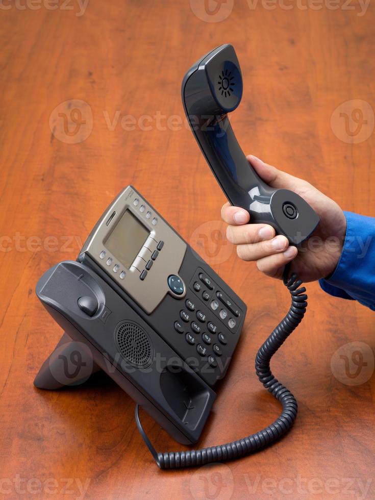 person holding telephone receiver in hand photo