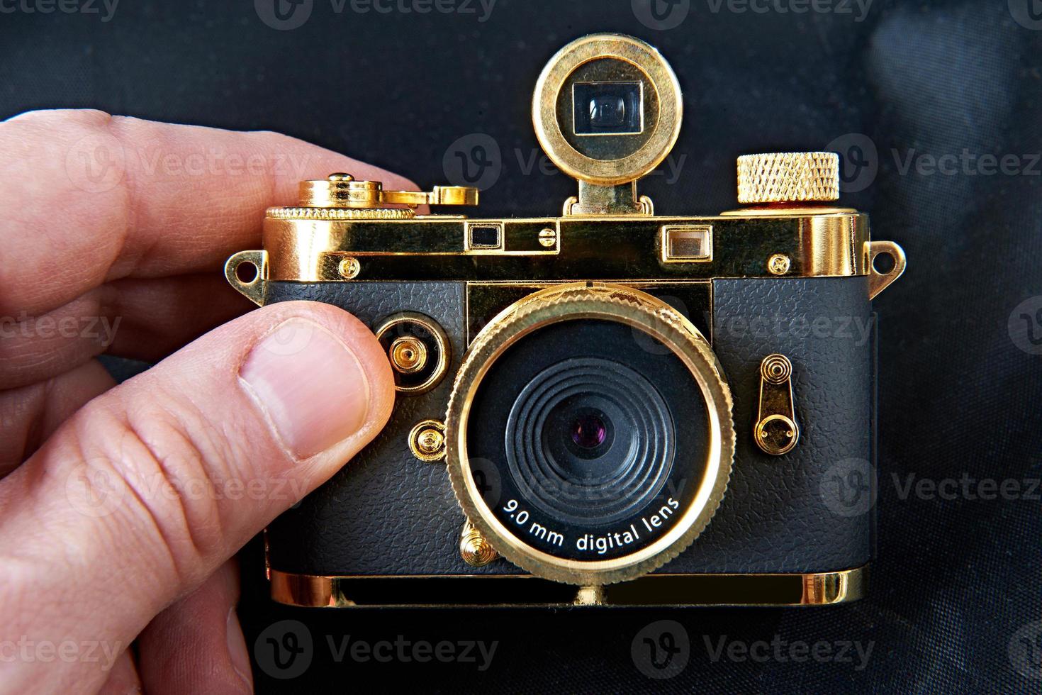 mini cámara dorada de regalo en mano grande foto