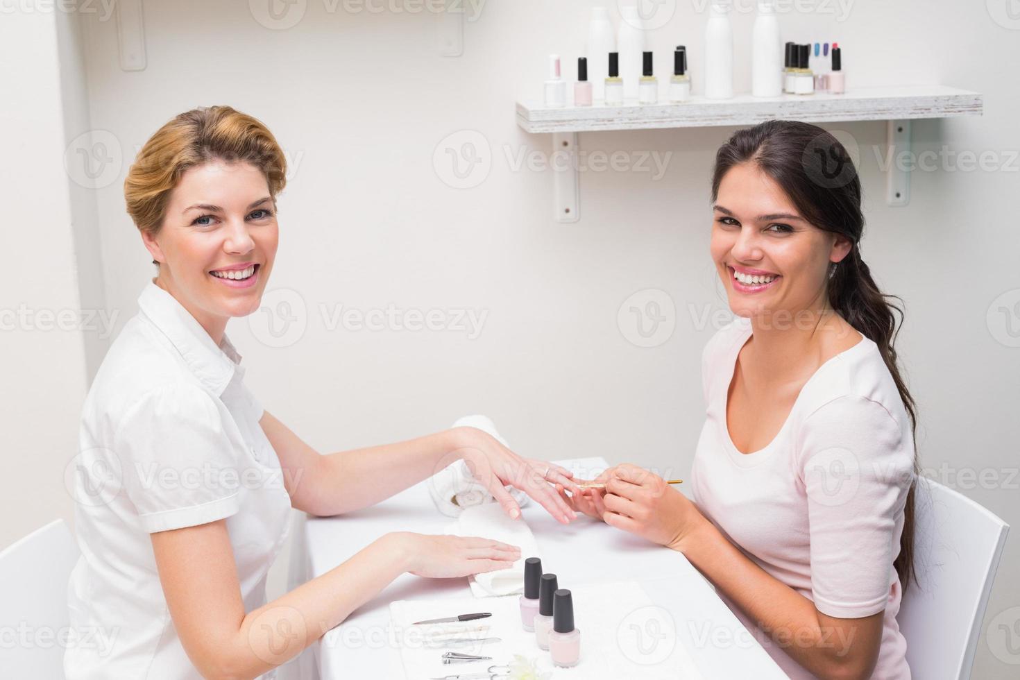 técnico de uñas dando al cliente una manicura foto