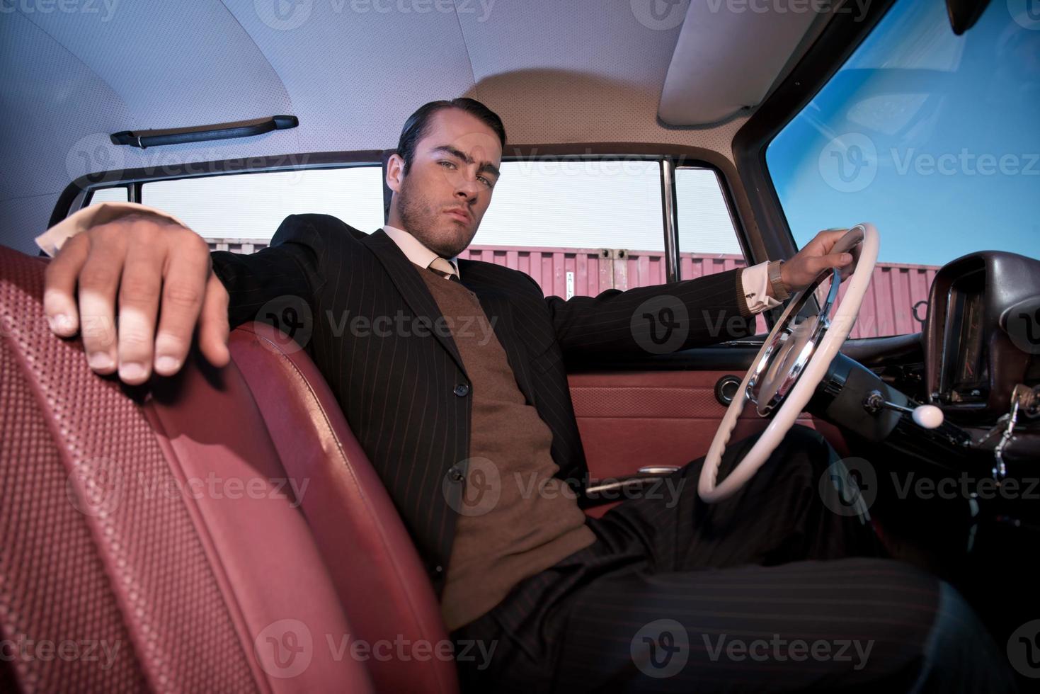 Retro fashion man wearing grey suit sitting in classic car. 1142705 ...