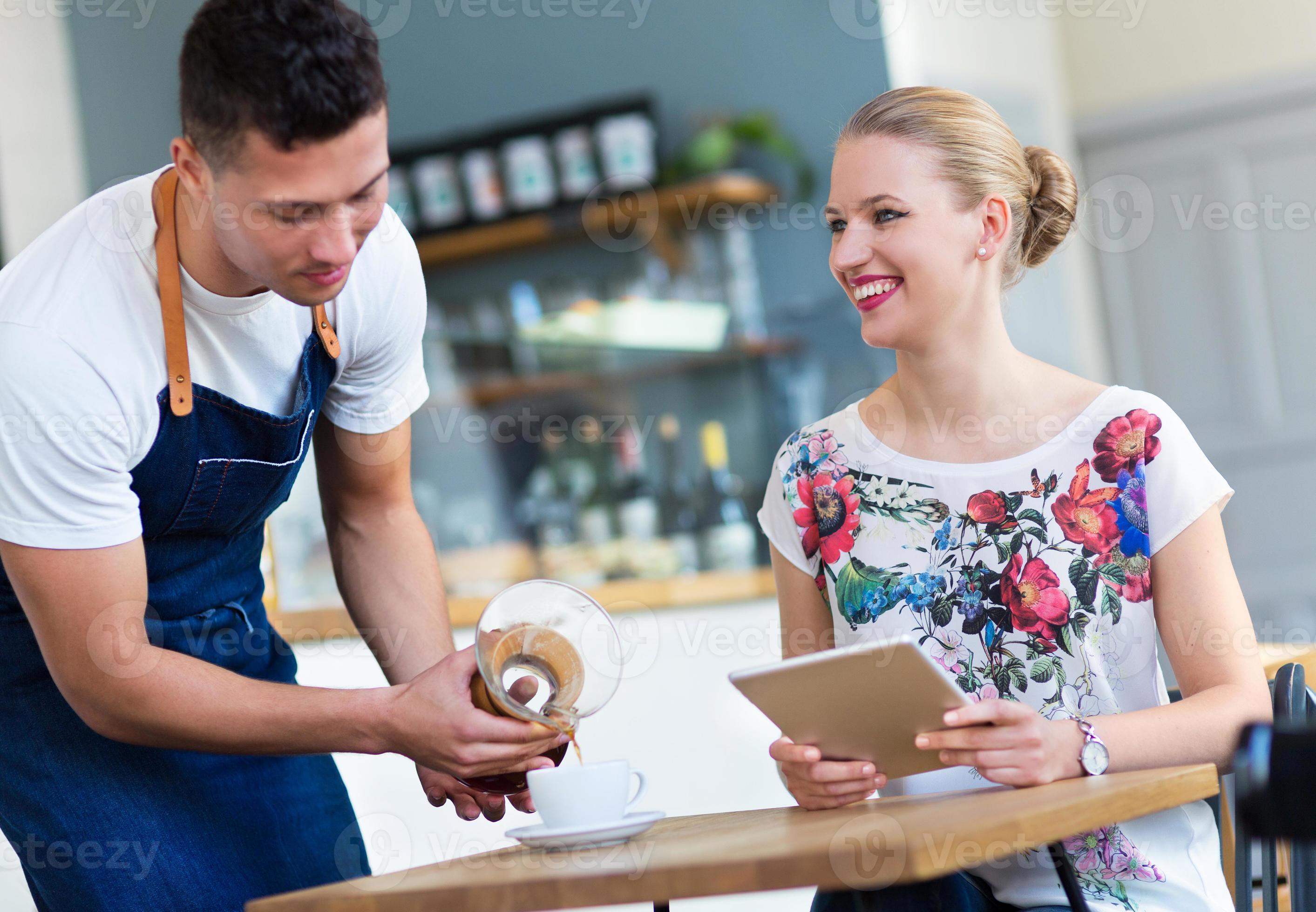 Waiter serving customer at the coffee shop 1142761 Stock Photo at Vecteezy