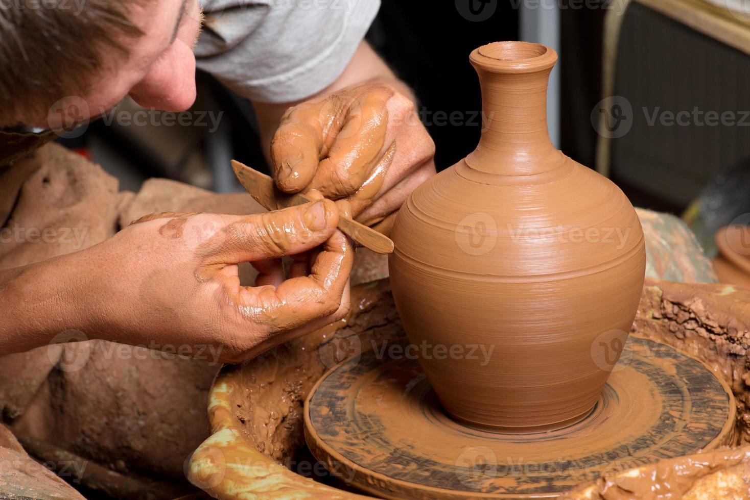 manos de un alfarero, creando una jarra de barro foto