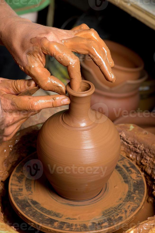 manos de un alfarero, creando una jarra de barro foto