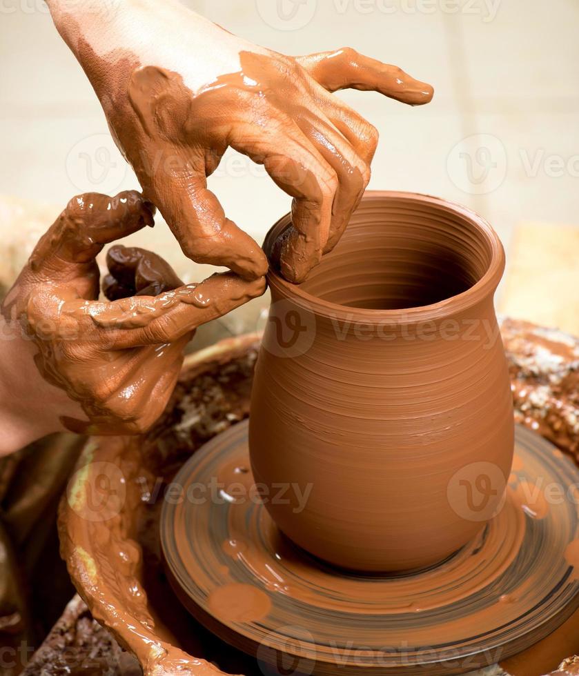 hands of a potter, creating an earthen jar photo