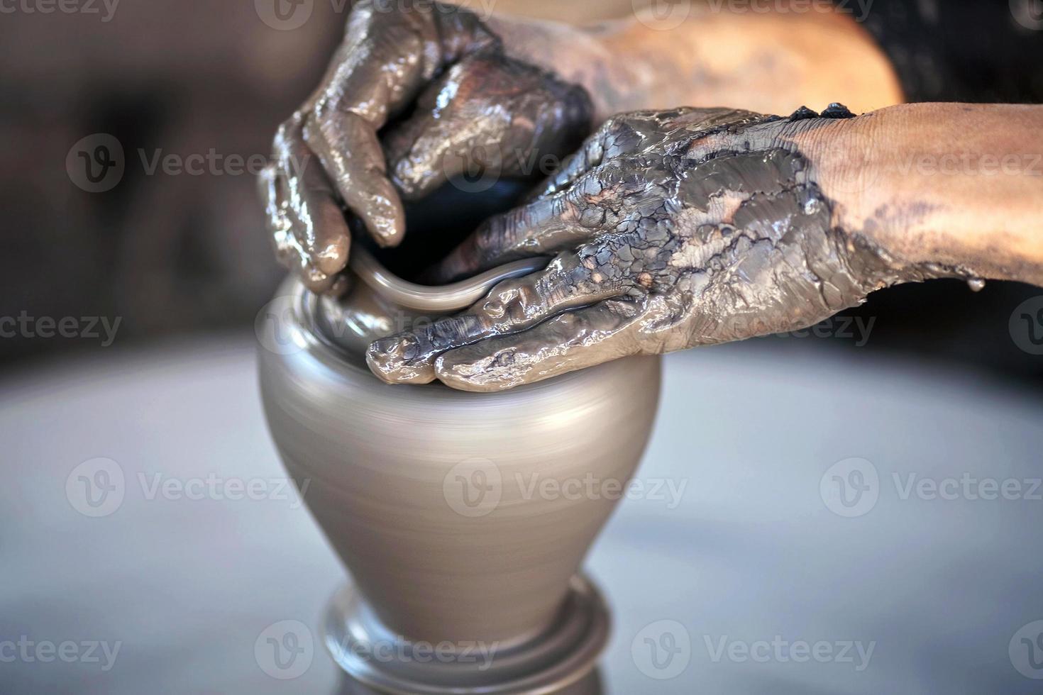 Hands of a potter, creating an earthen jar photo