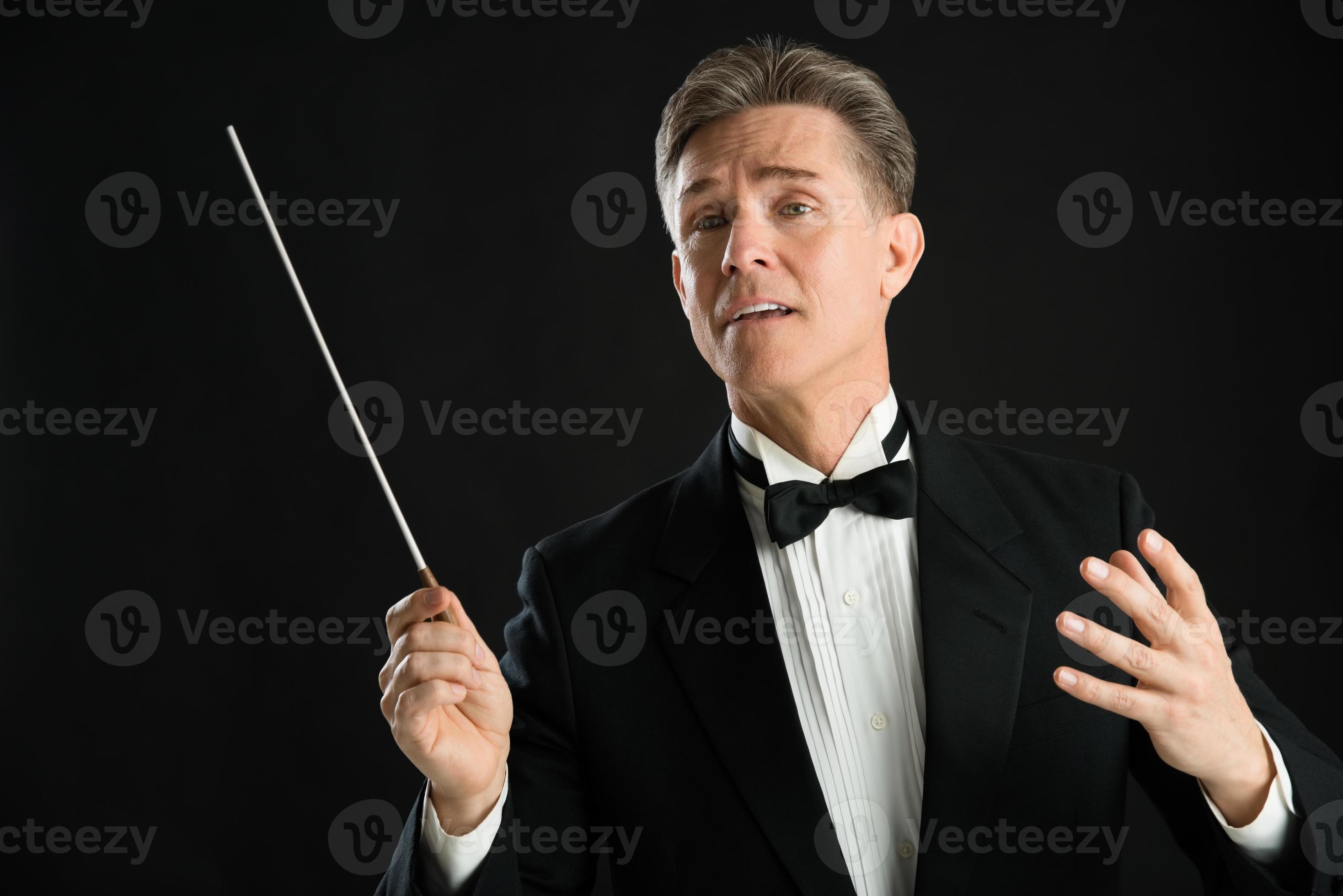 Music Conductor Looking Away While Directing With His Baton 1168654 Stock Photo at Vecteezy