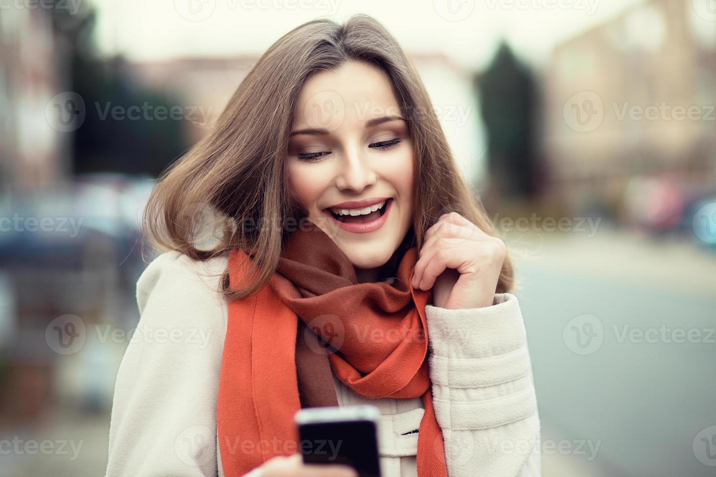 mensajes de texto de mujer. Primer plano joven feliz sonriente alegre hermosa mujer niña mirando móvil celular lectura enviando sms aislado paisaje urbano fondo al aire libre. expresión facial positiva emoción humana. multicultural, raza mixta, modelo ruso asiático foto