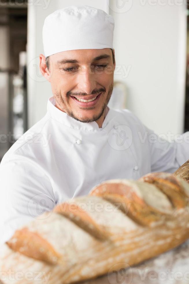 feliz panadero sacando pan fresco foto