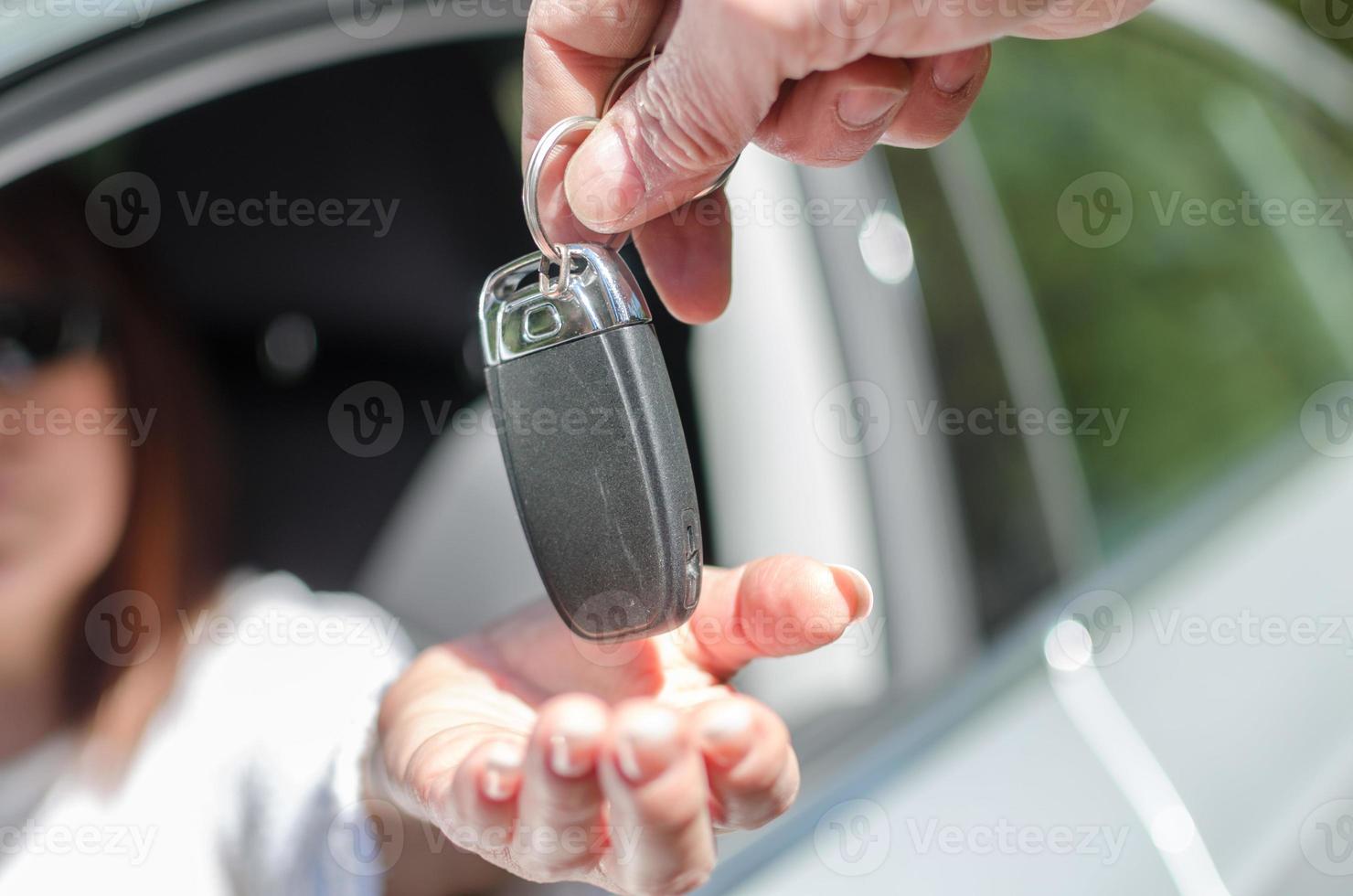 hombre dando la llave del auto a una mujer foto