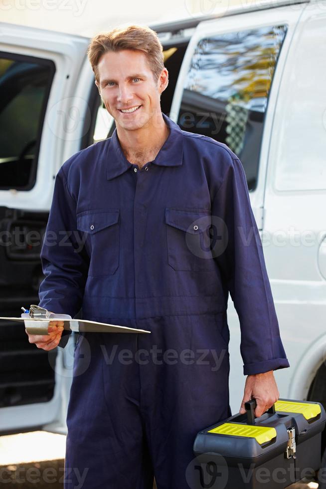 Un retrato de un reparador delante de una furgoneta foto