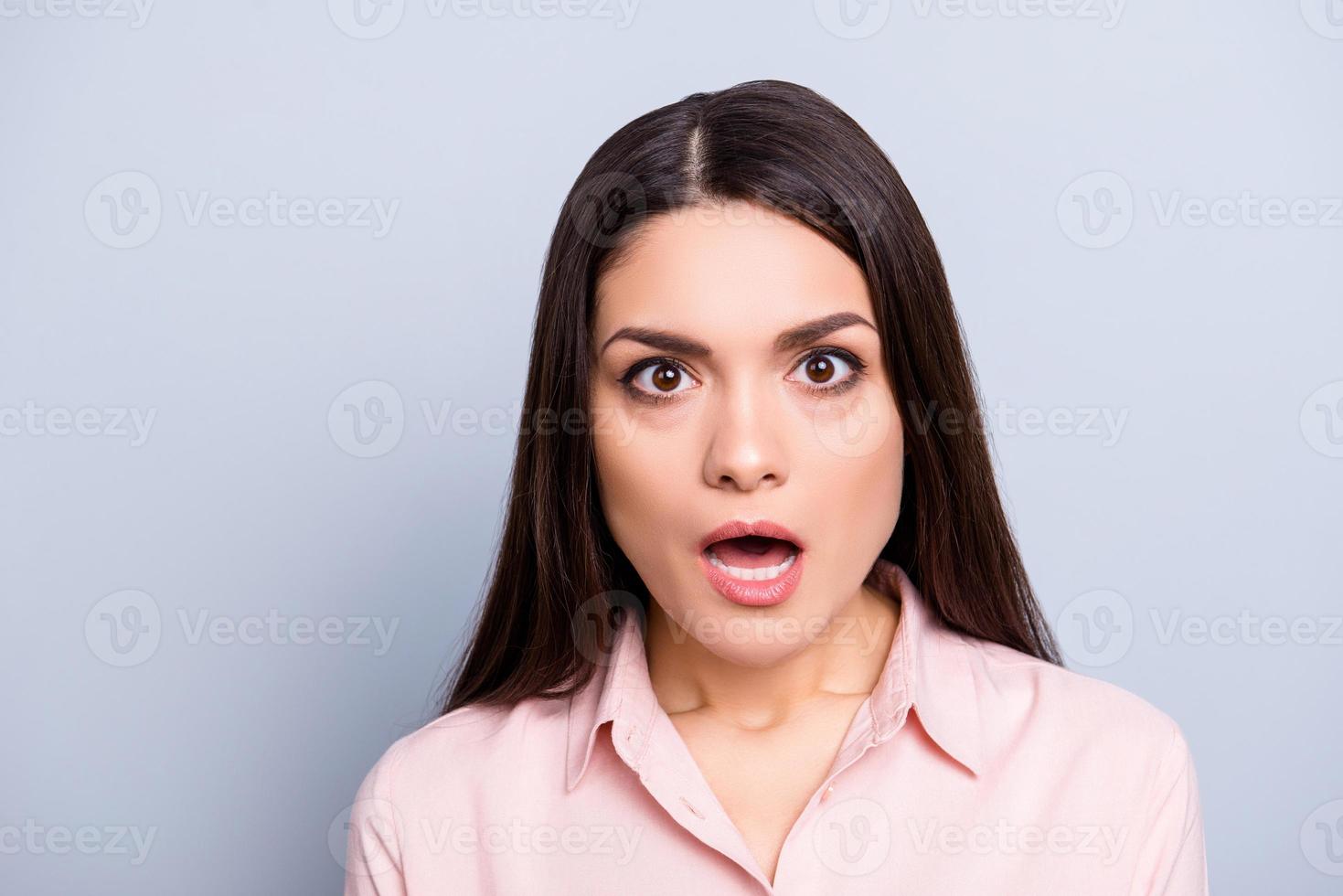Portrait of shocked, scared, afraid, impressed, stressed, unexpected woman in classic shirt with wide open mouth eyes looking at camera isolated on grey background photo