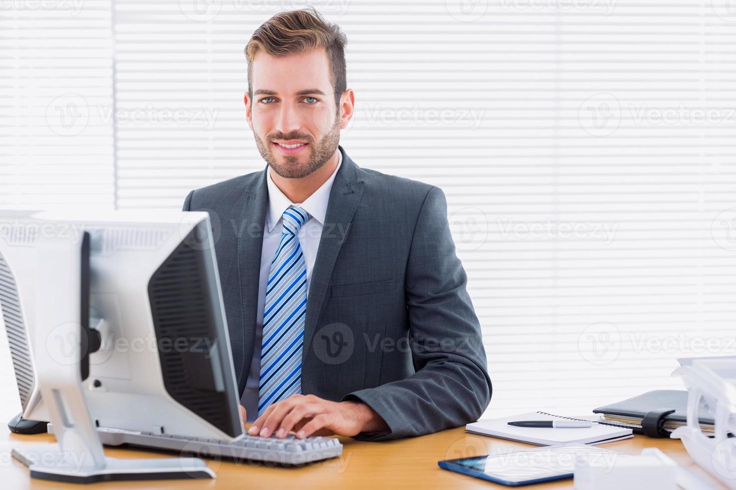Young businessman using computer at office desk photo