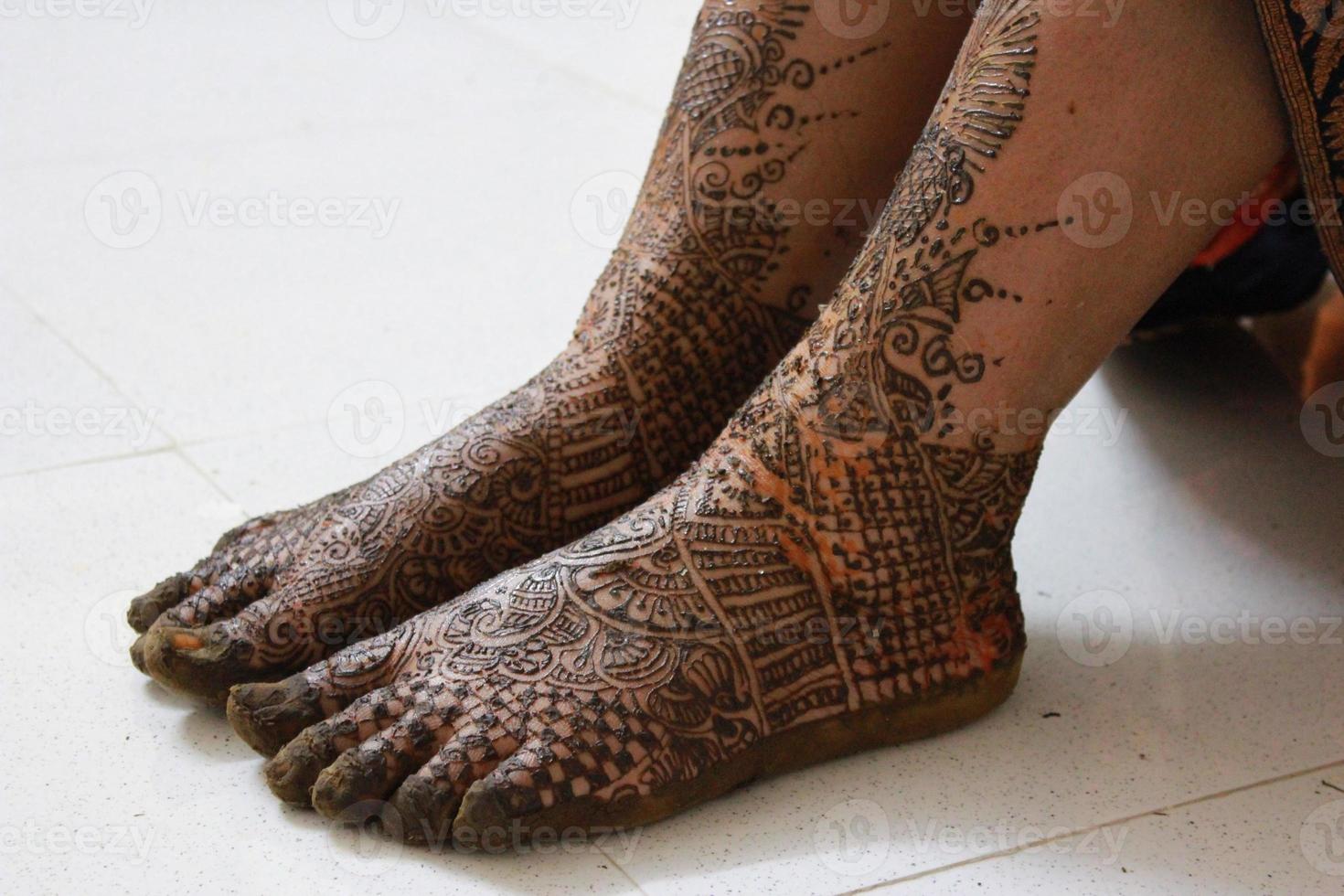 Closeup woman legs with henna tattoo over black stone floor Stock Photo   Adobe Stock