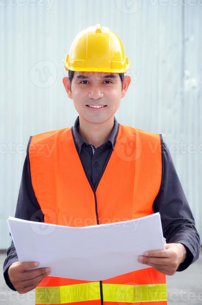 Ingeniero o capataz asiático con chaleco de seguridad y casco foto
