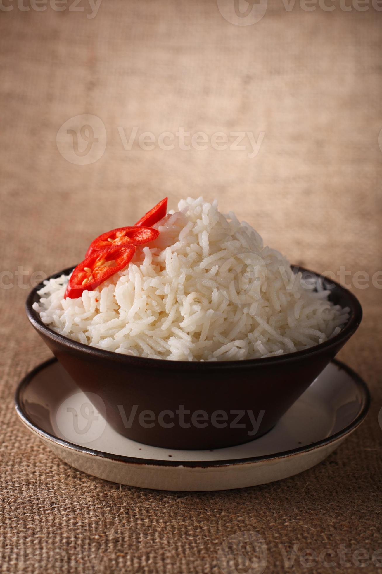 Tazón de arroz con chiles frescos sobre fondo marrón rústico, foto