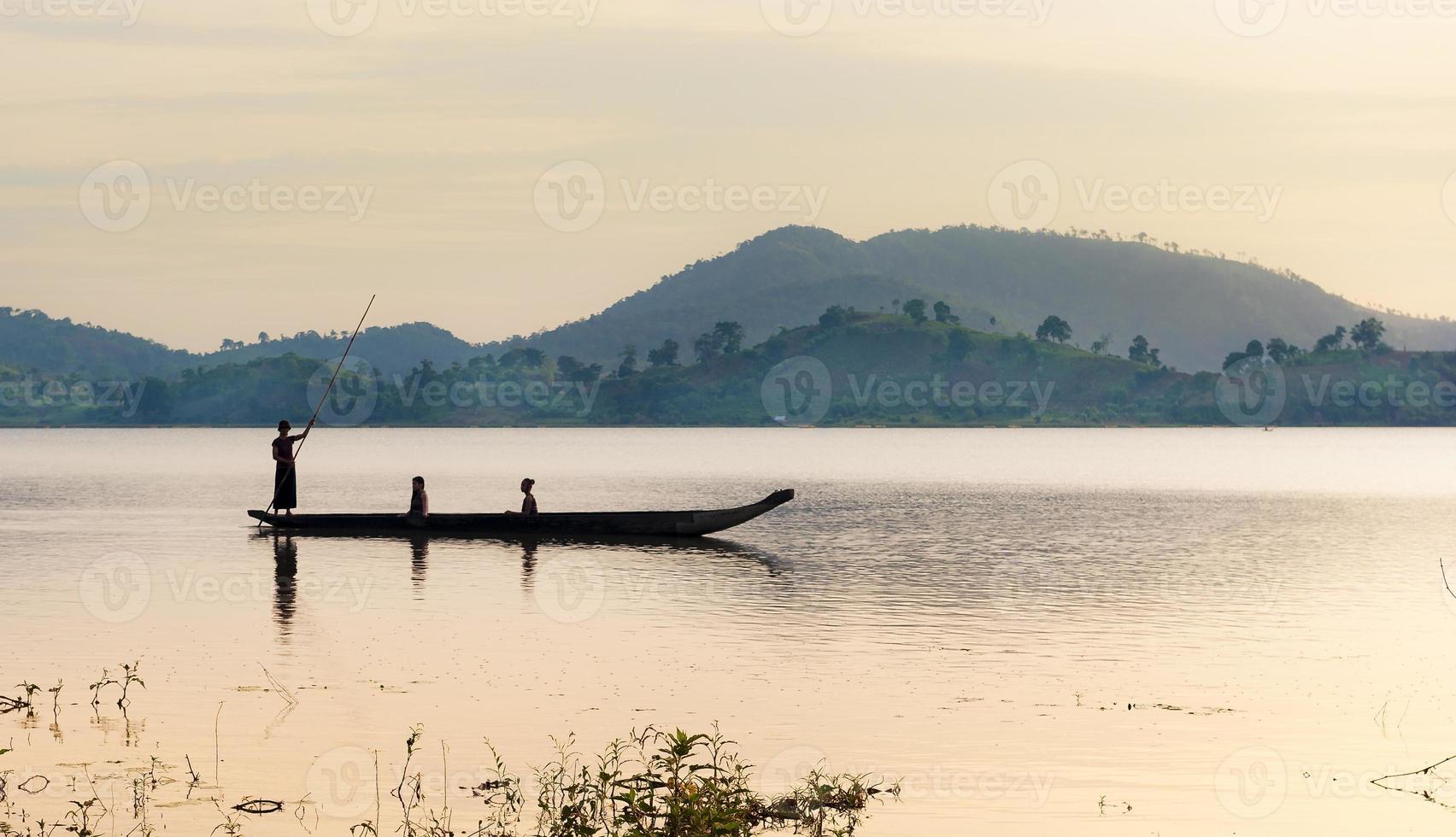 Ede women rowing dugout boat on lake at sunrise photo