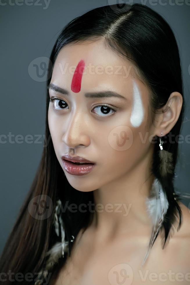 belleza joven asiática con maquillaje como pocahontas, rojo foto