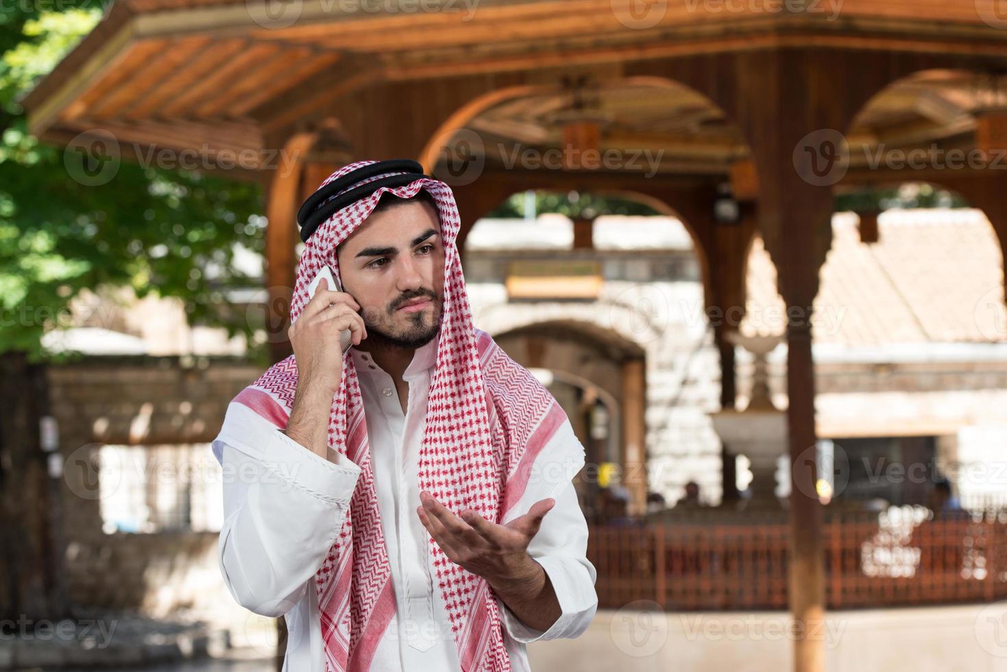 apuesto hombre del Medio Oriente hablando por teléfono móvil foto