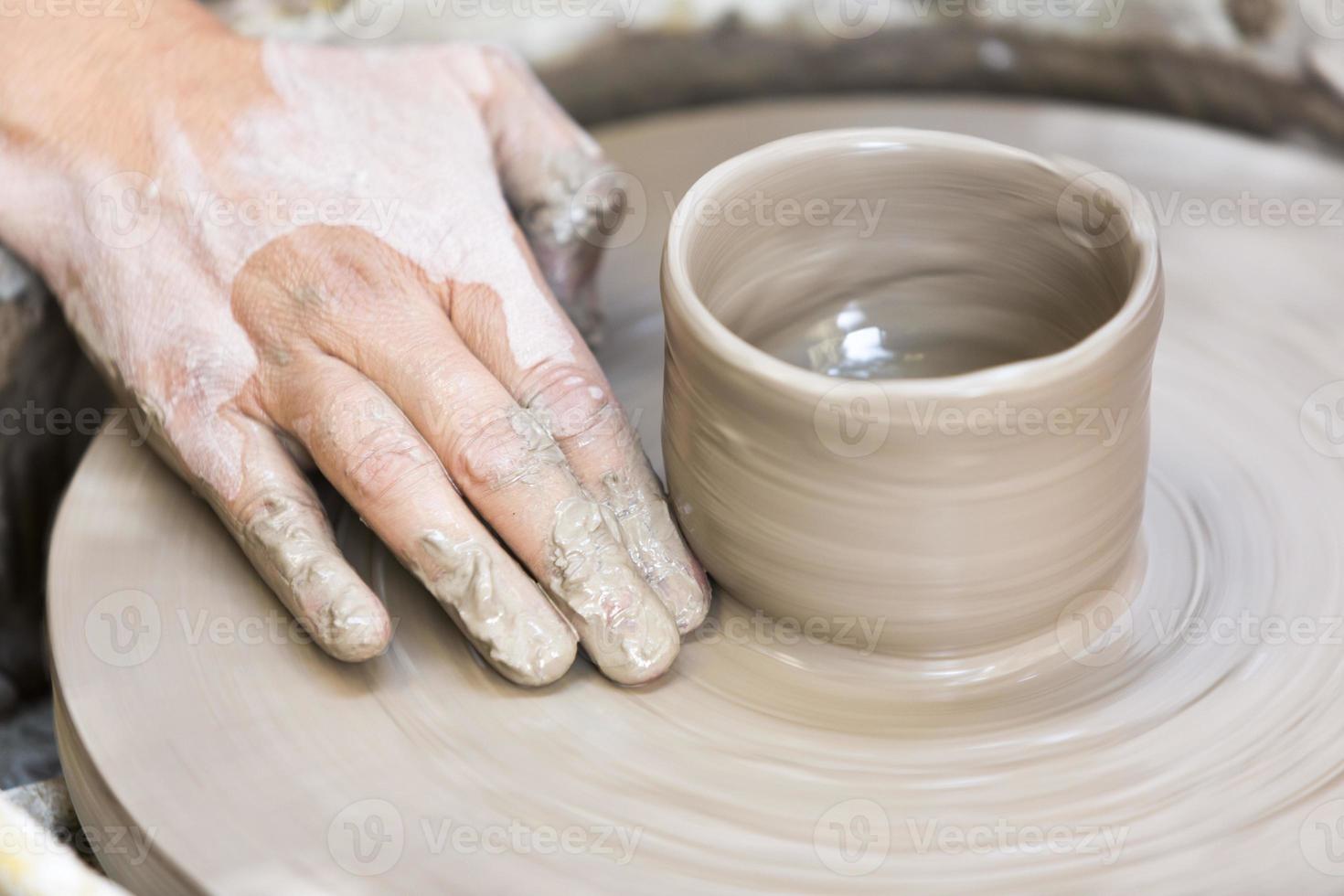 haciendo una taza de cerámica en el volante foto