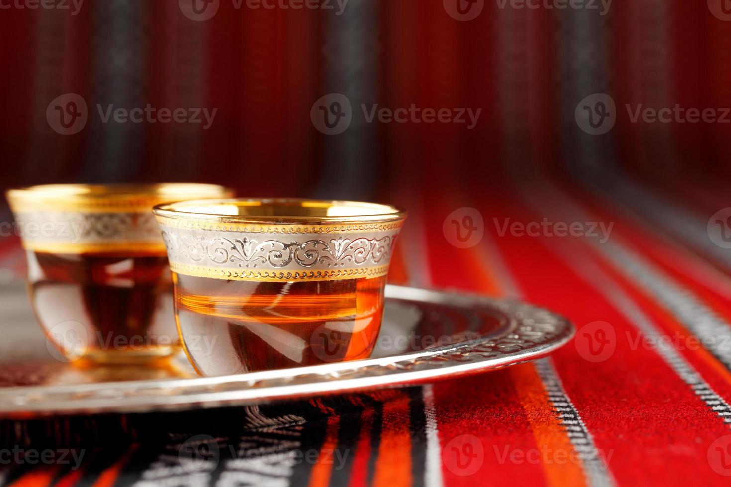 bandeja de tazas de té árabe en tela tejida árabe foto