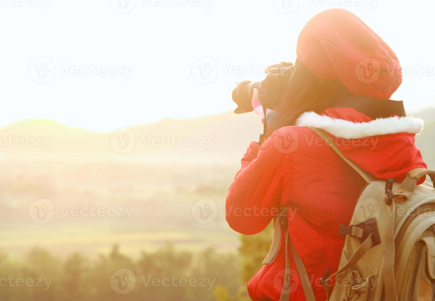 Nature photographer taking pictures during hiking trip photo