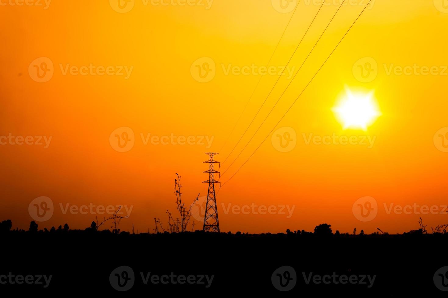 poste de alta tensión con cielo naranja foto