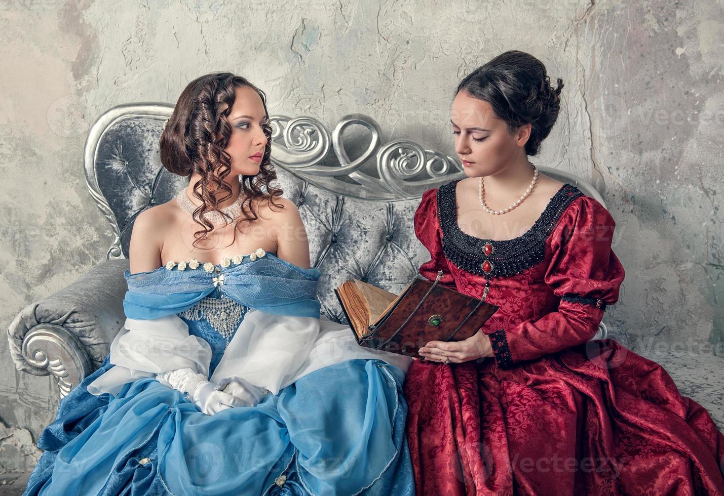 Dos hermosas mujeres en vestidos medievales en el sofá leyendo libro 1216675 Foto de stock en Vecteezy Dos hermosas mujeres en vestidos medievales en el sofá leyendo libro 1216675 Foto de stock en Vecteezy