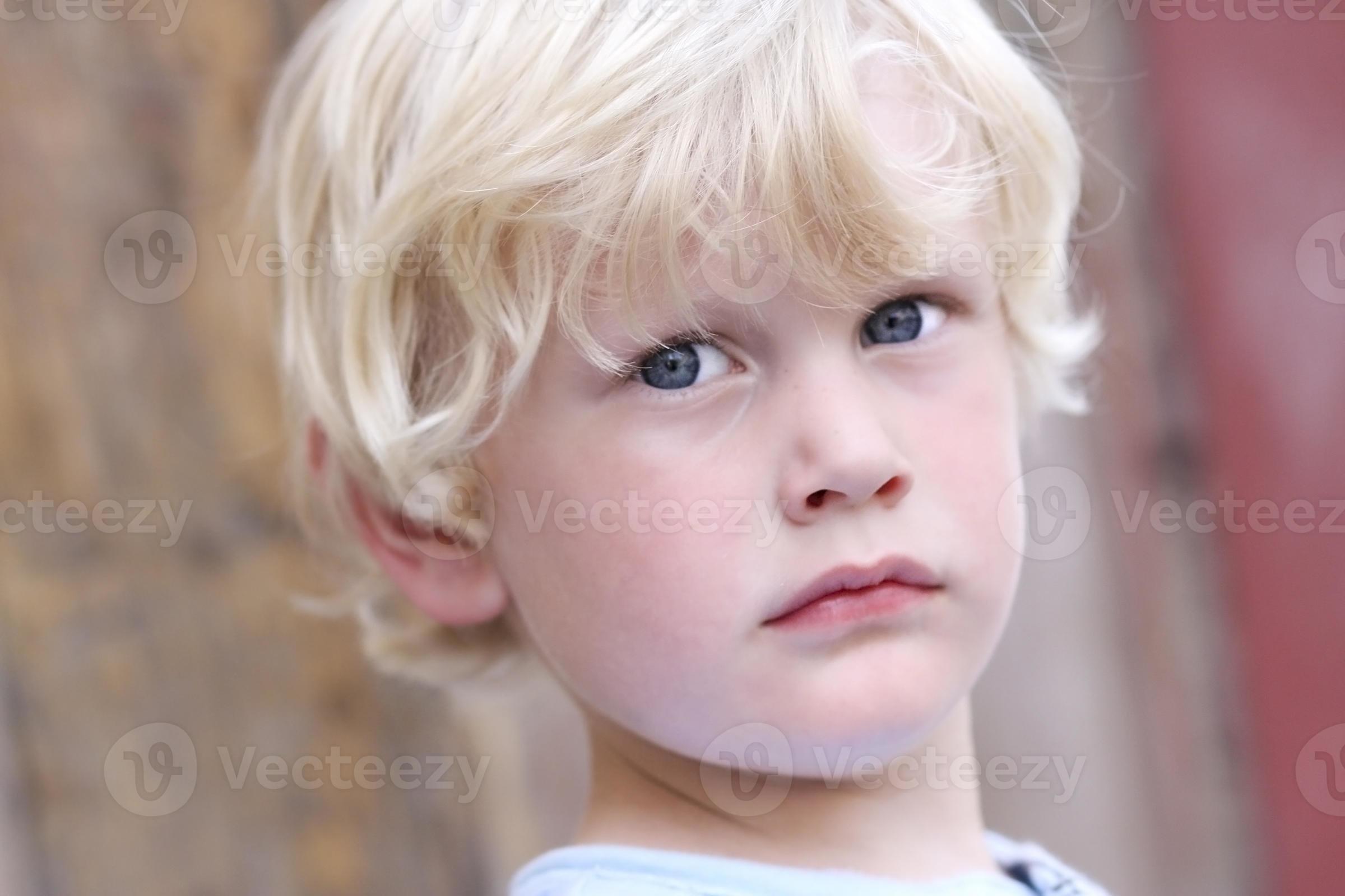 Blonde little boy with blue eyes, serious look. 1217923 Stock Photo at  Vecteezy