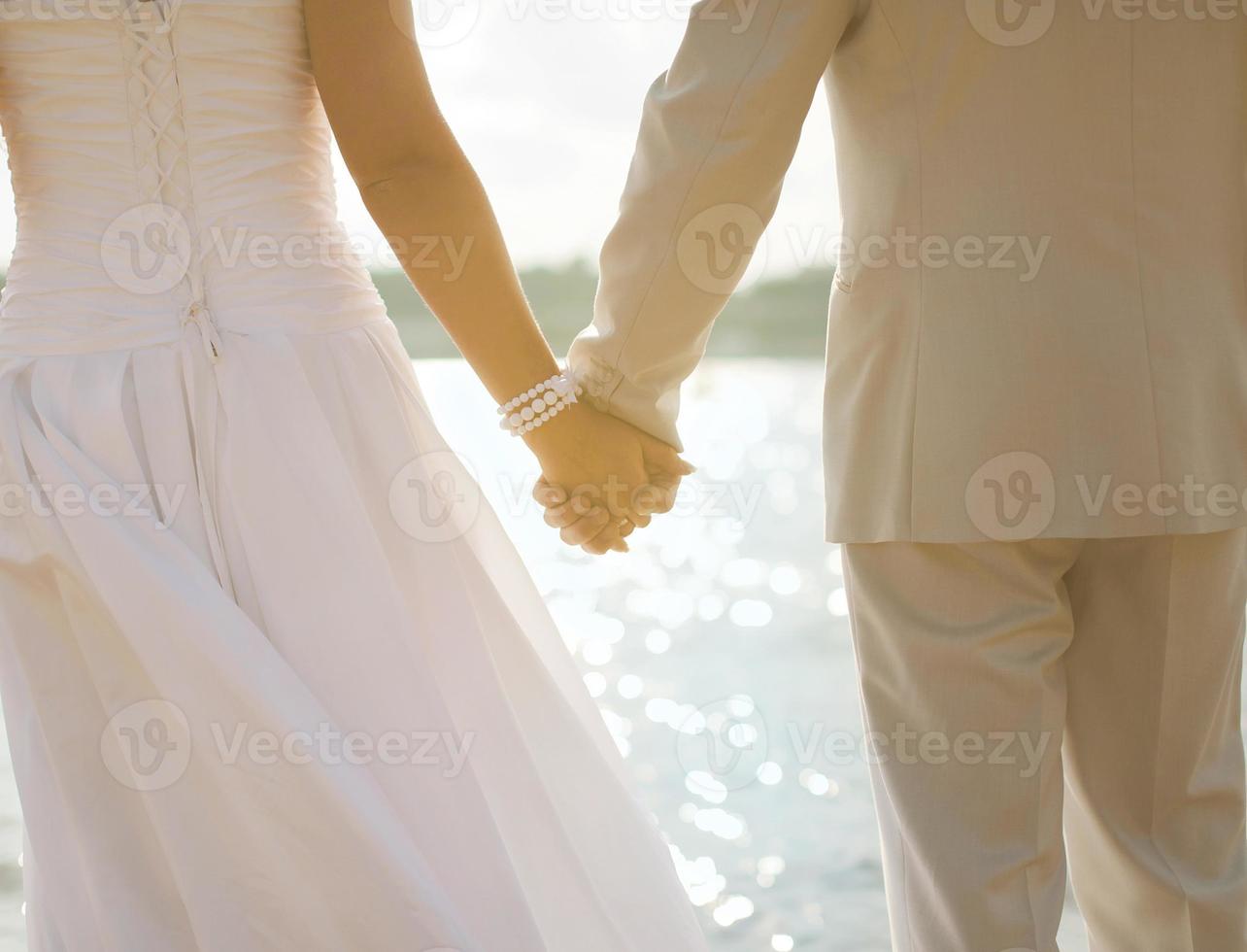 Bride and groom holding hands photo
