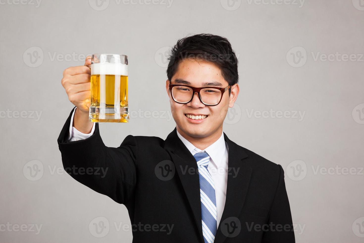 empresario asiático aplaude con jarra de cerveza foto