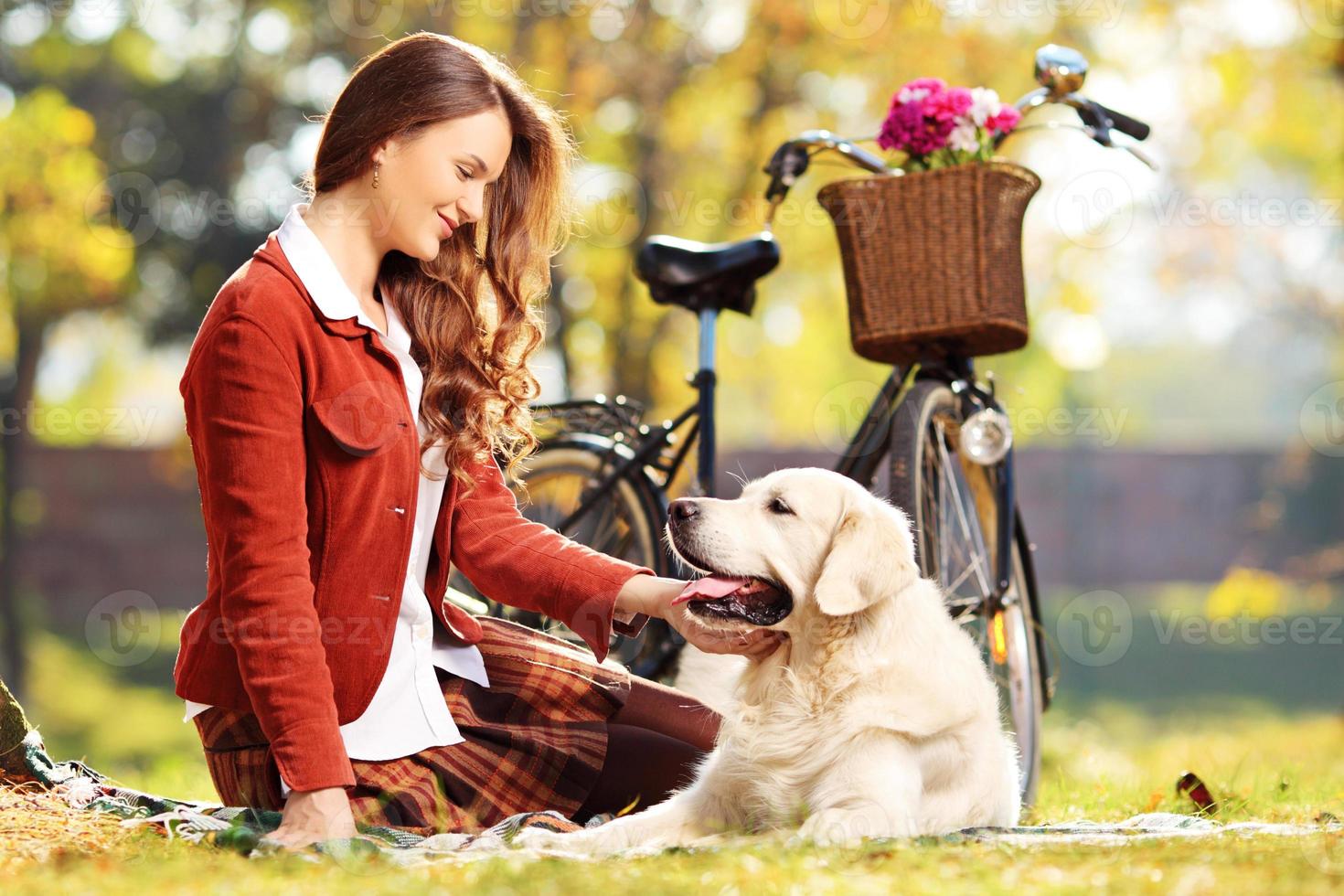 hermosa mujer sentada en un pasto con su perro foto