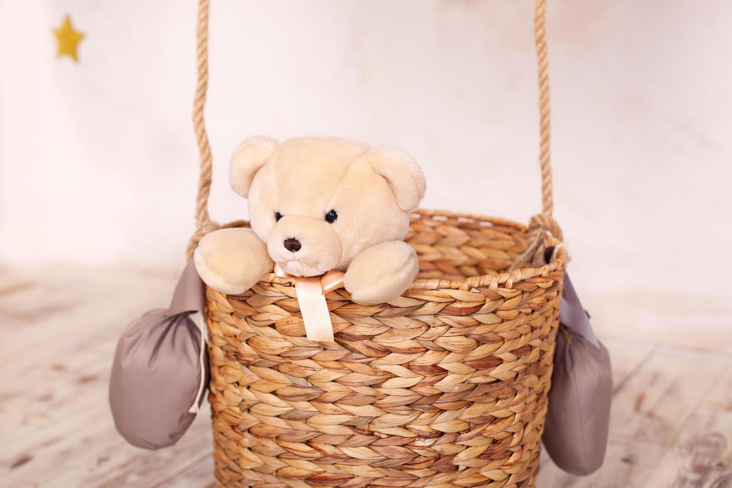 Teddy bear toy sitting in the balloon basket photo