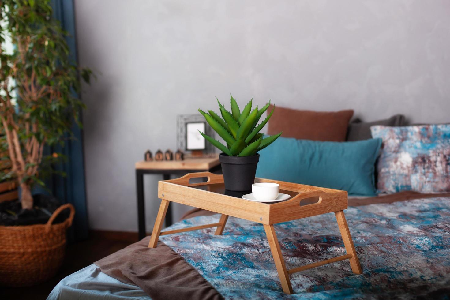 Interior del dormitorio con una mesita en la cama foto