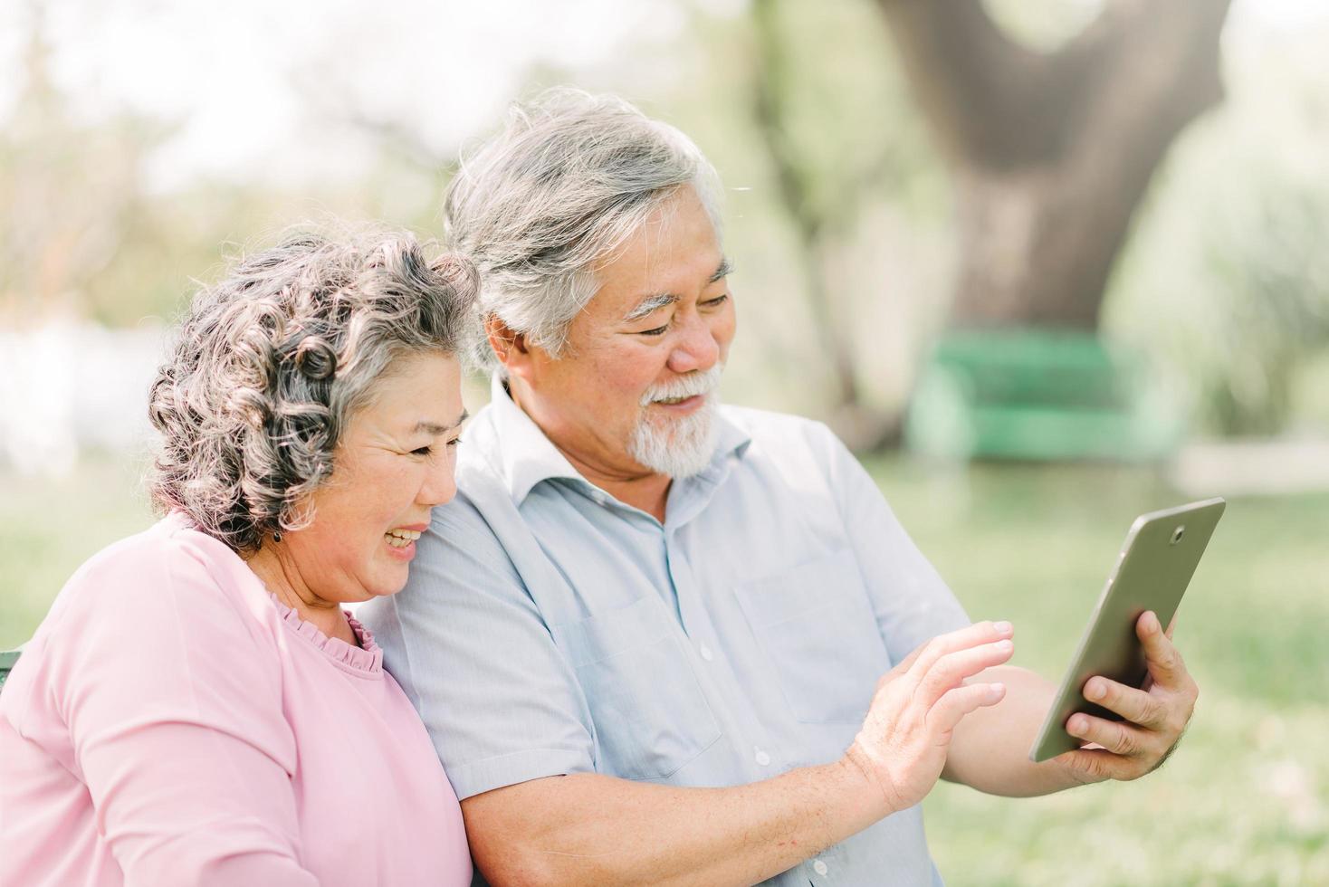 Senior couple using tablet outdoors photo