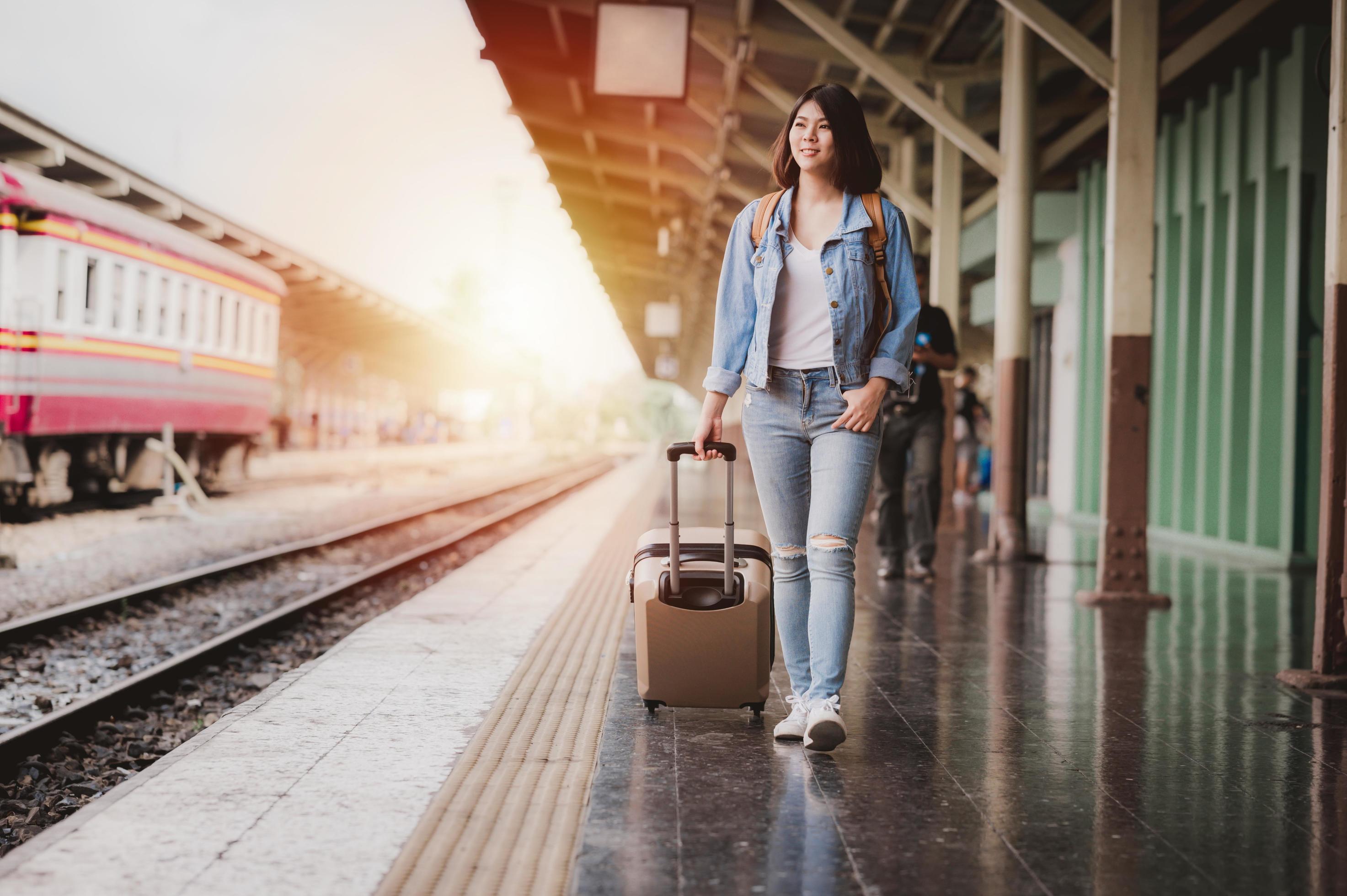 Woman with luggage at train station 1223400 Stock Photo at Vecteezy