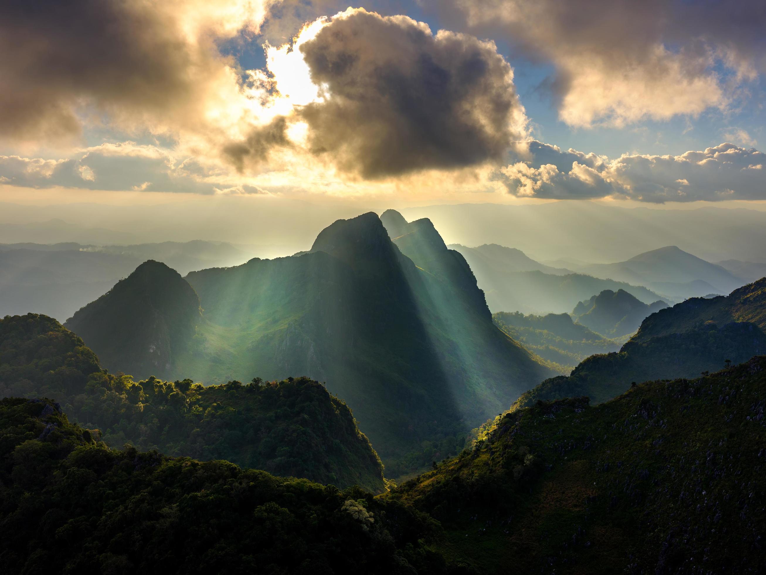 Sun shining through clouds and mountains 1223498 Stock Photo at Vecteezy