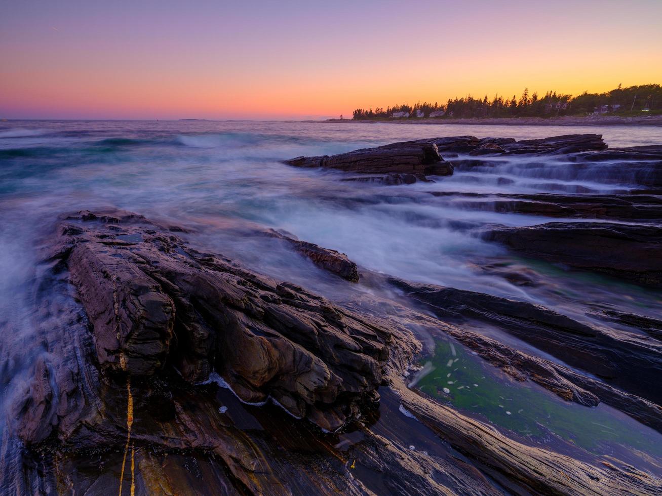 Long-exposure of waves on rocks photo