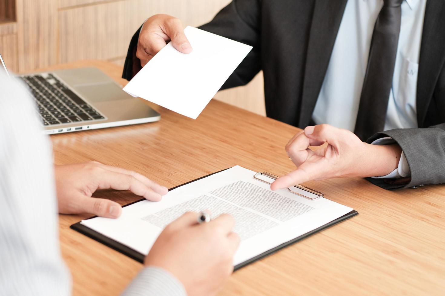 Businessman giving resignation letter to boss photo