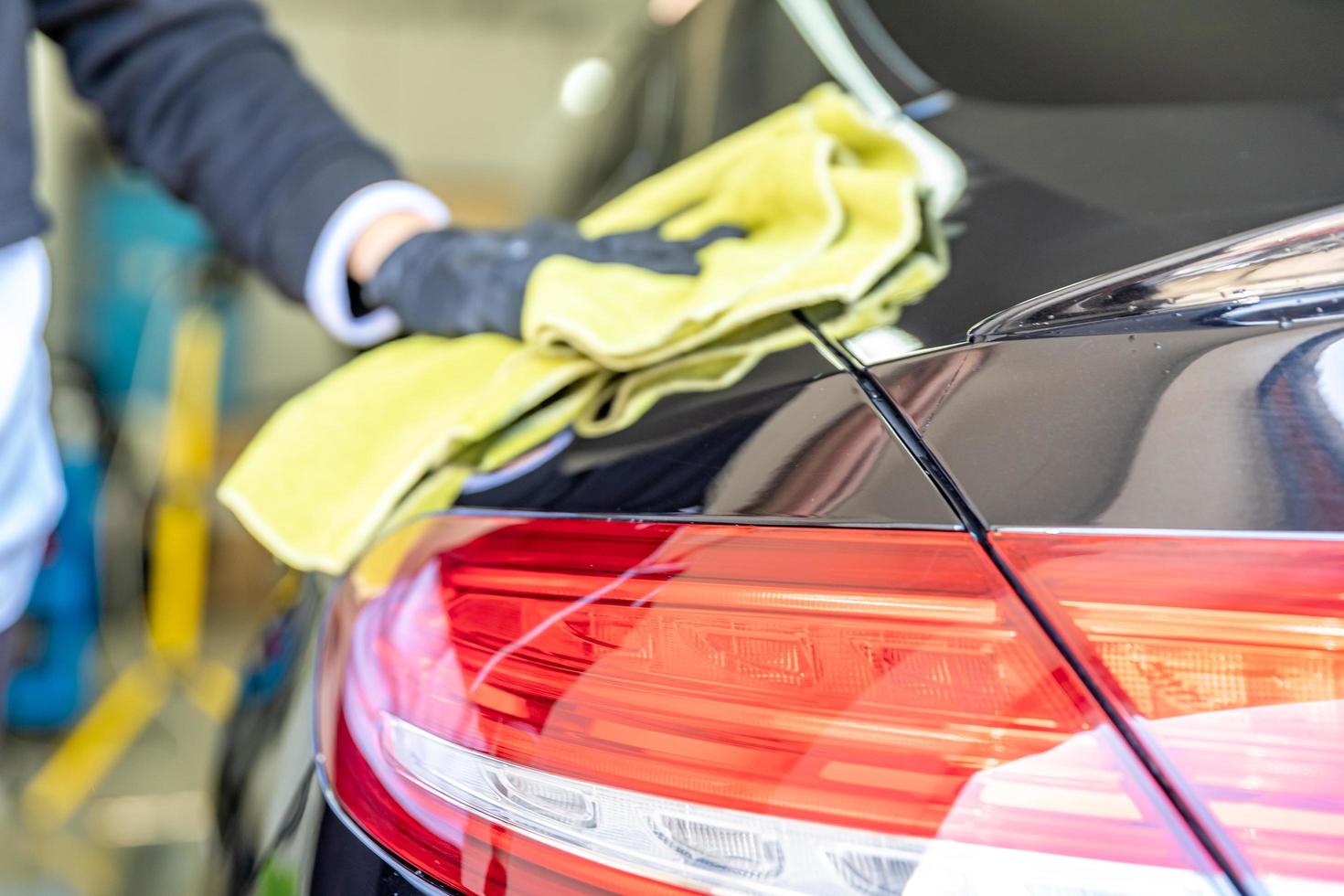 Mechanic polishing car body in the garage photo