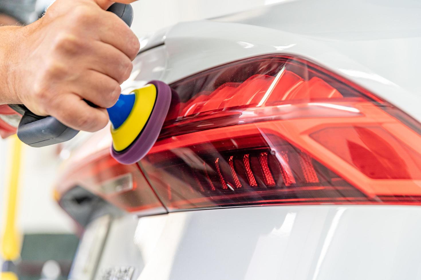 Car mechanic polishing bumper  photo