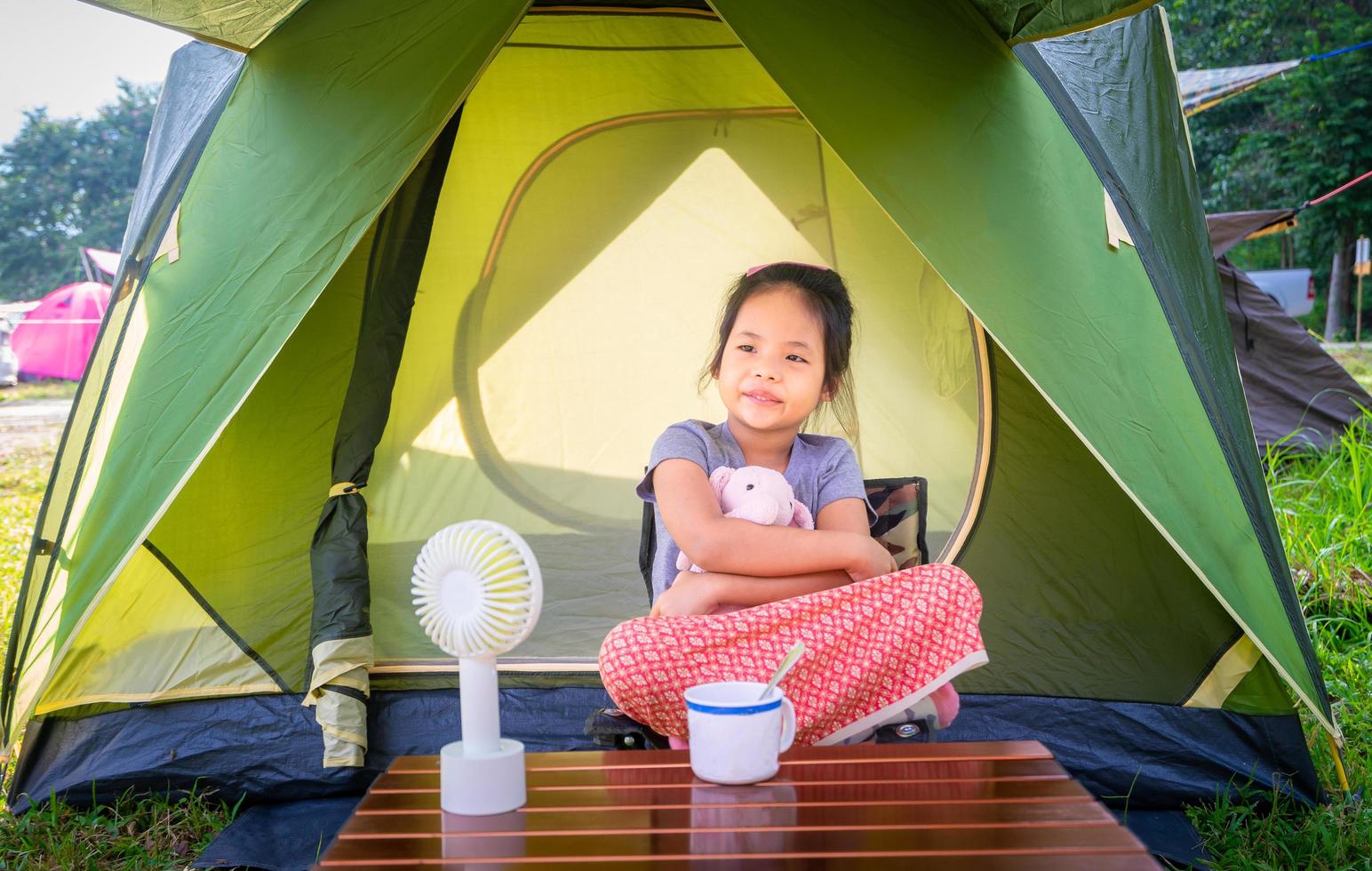 niña sentada en la tienda mientras acampaba foto