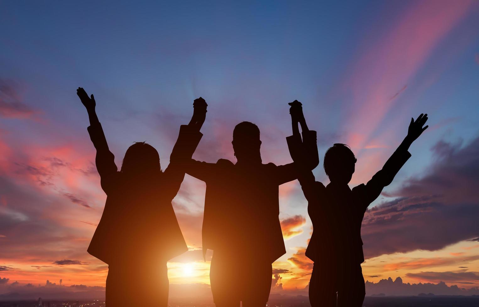 tres personas siluetas delante del atardecer foto