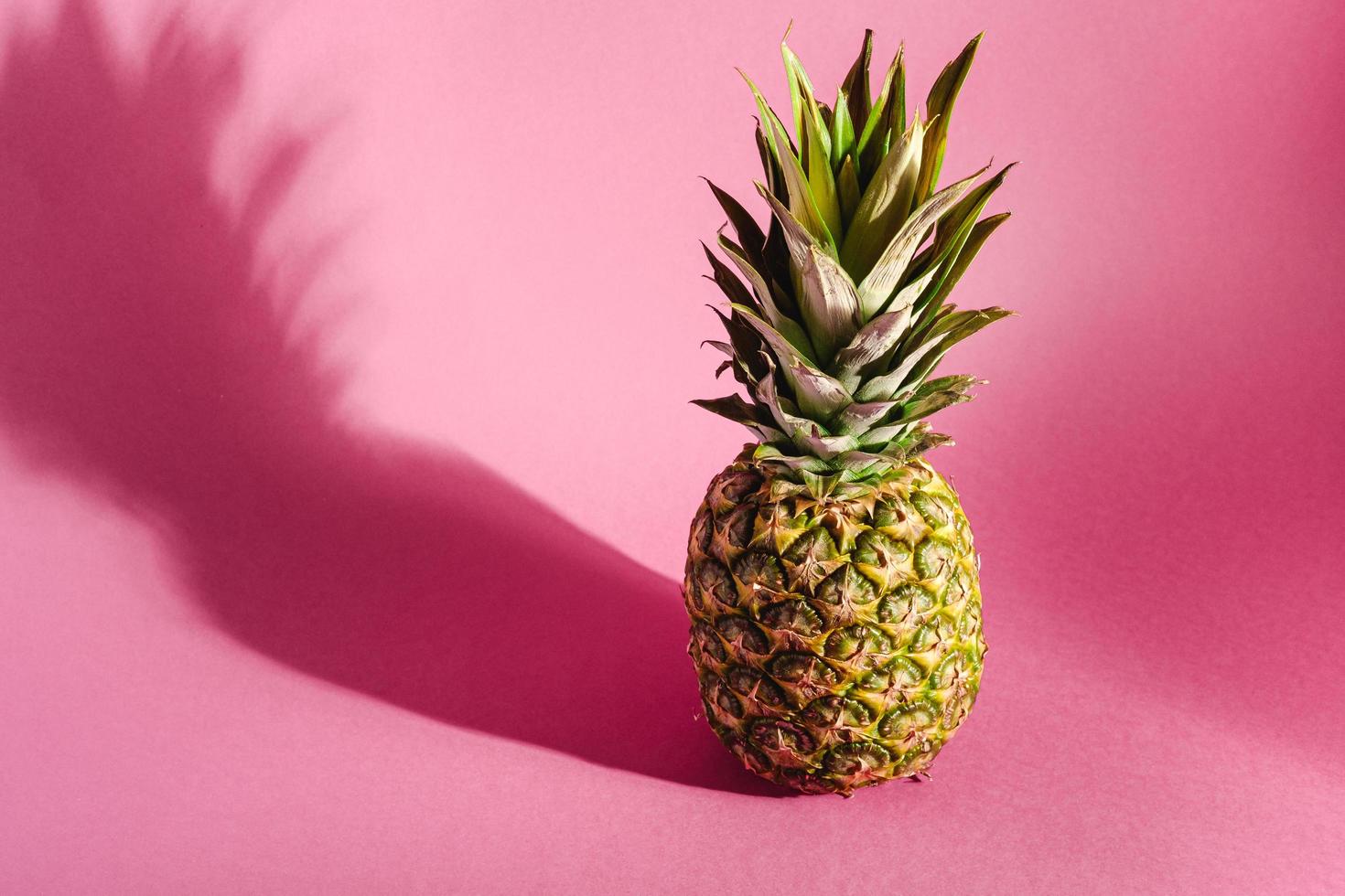 Pineapple on pink purple background with hard shadow photo