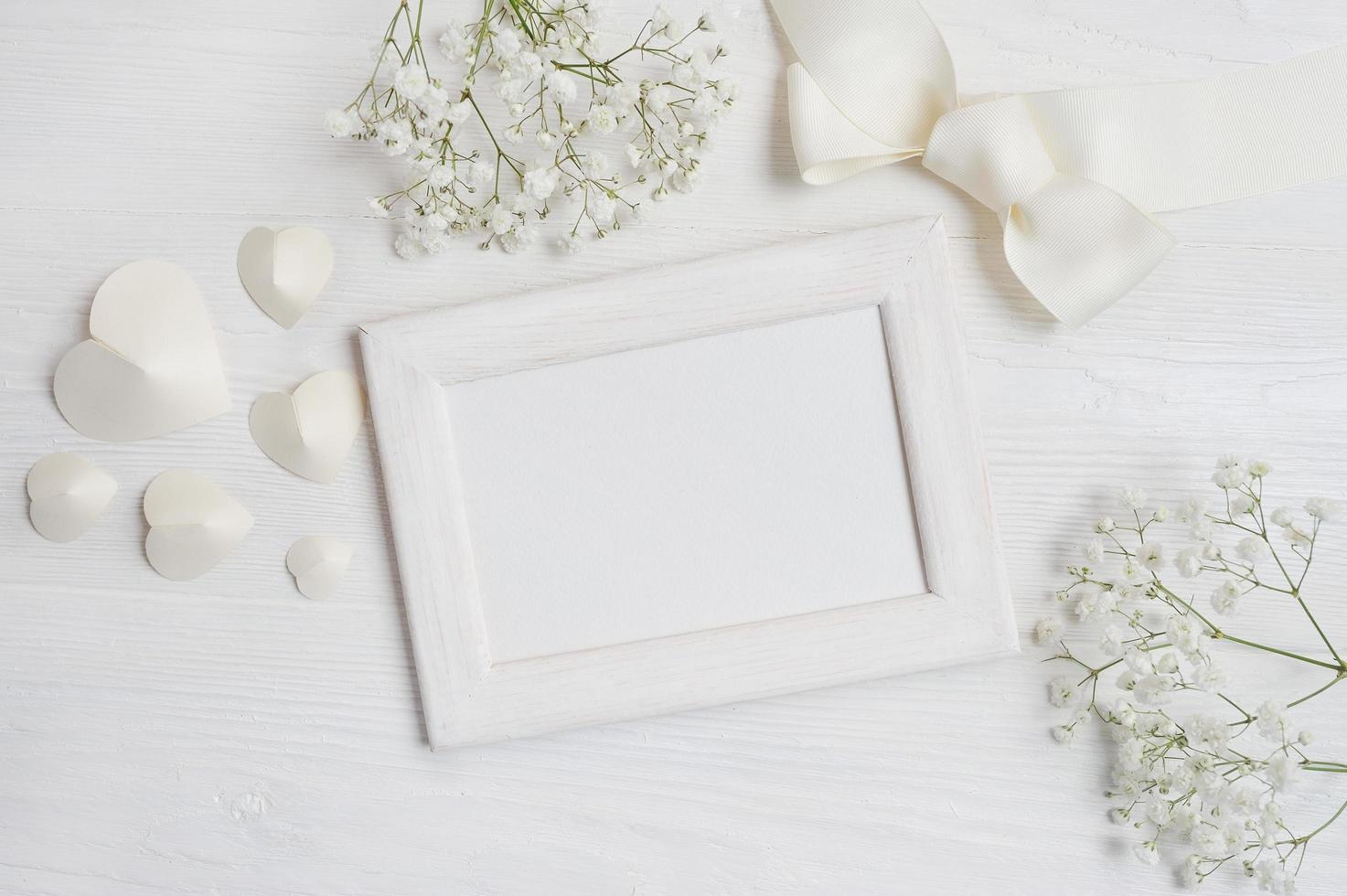 White wooden frame with hearts and flowers photo