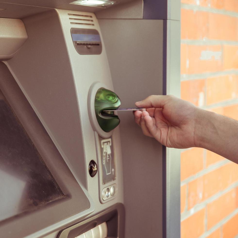 Customer uses ATM to withdraw cash photo