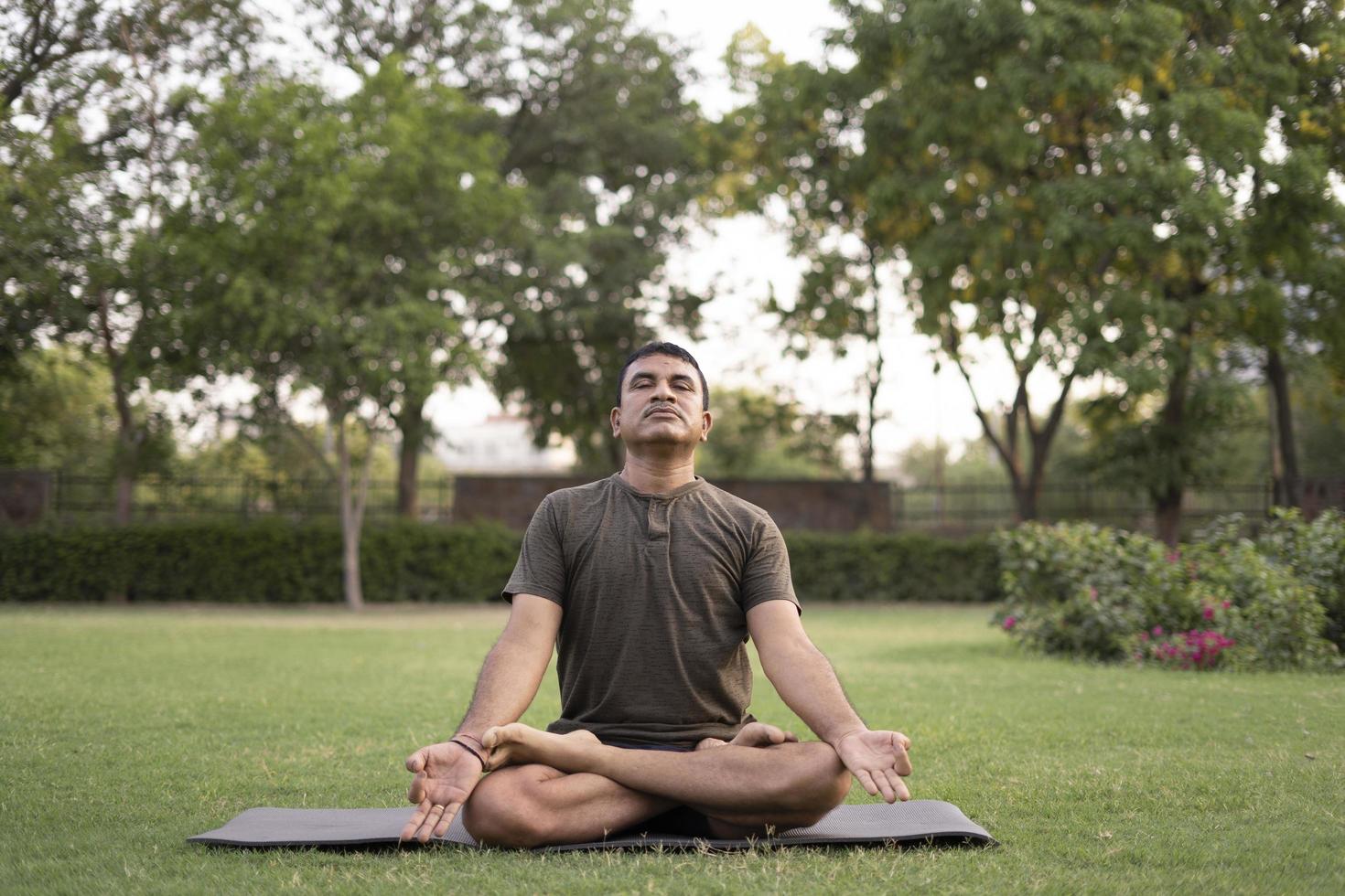 hombre haciendo yoga al aire libre foto